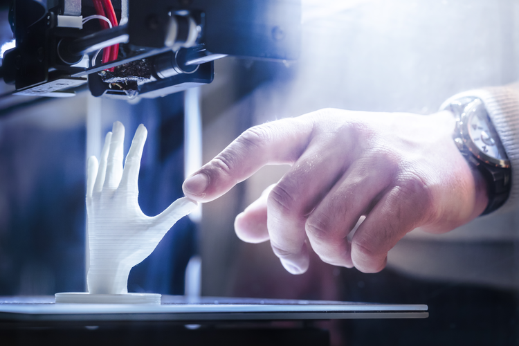 Hombre interactuando con un modelo impreso en 3D de una mano 